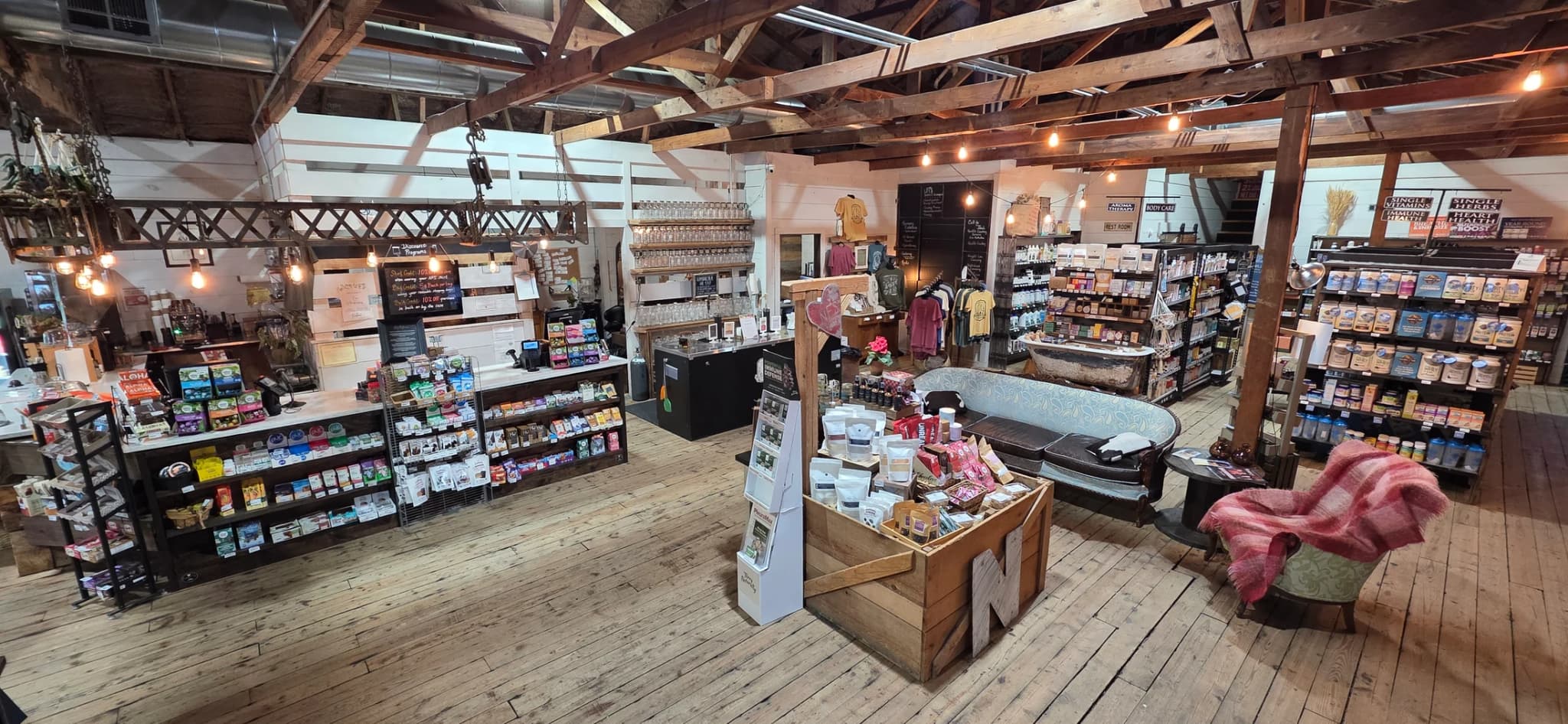Inside the Natural Food Store — timber trusses, string lights, and wood floors over the whole shop